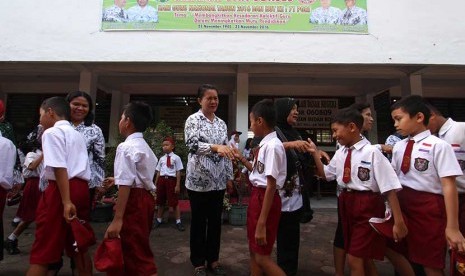 Sejumlah siswa menyalami guru mereka seusai mengikuti upacara di Sekolah Dasar Negeri 060813 Medan, Sumatera Utara, Jumat (25/11). 