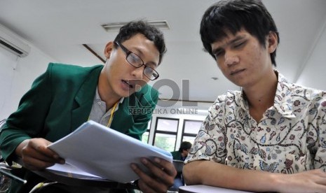 Sejumlah siswa penyandang tuna netra dibantu oleh mahasiswa panitia dalam mengerjakan Ujian Seleksi Bersama Masuk Perguruan Tinggi (SBMPTN) 2013 di Fakultas Hukum UI, Depok,  Selasa (18/6).   (Republika/Rakhmawaty La'lang)