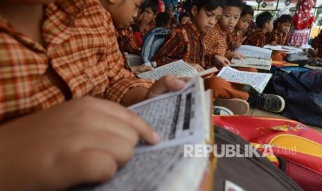 Sejumlah siswa SD 15 Cakranegara membaca Al Quran saat menonton MTQ di Islamic Center Kota Mataram, Nusa Tenggara Barat, Kamis (4/8)