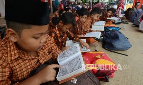 Siswa di Kota Mataram, NTB, membaca Alquran (ilustrasi). Siswa SD-SMP beragama Islam di Mataram menggunakan busana Muslim selama Ramadhan.