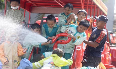 Sejumlah siswa SD didampingi petugas pemadam kebakaran menggunakan alat penyemprot air saat pengenalan profesi petugas damkar di Pos Pemadam Kebakaran, GDC, Depok, Jawa barat, Rabu (21/6/2022). Kegiatan tersebut bertujuan untuk memberikan pengenalan dan edukasi tentang tugas pemadam kebakaran kepada anak usia dini. 