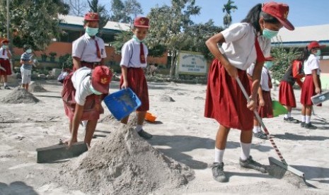 Sejumlah siswa SD membersihkan halaman sekolah pasca erupsi Gunung Sinabung, di Desa Payung, Karo, Sumatra Utara, Selasa (20/2). 