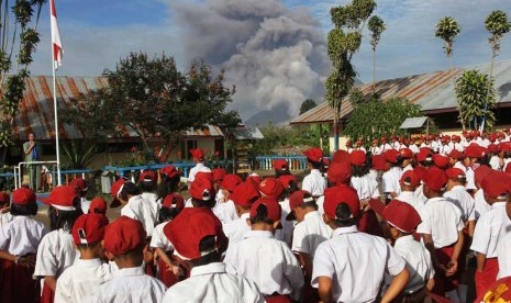 Sejumlah siswa SD Negeri 040482 mengikuti upacara bendera pada hari pertama masuk sekolah, ketika terjadi erupsi Gunung Sinabung, di Desa Gajah, Karo, Sumut, Senin (6/1).   (Antara/Irsan Mulyadi)