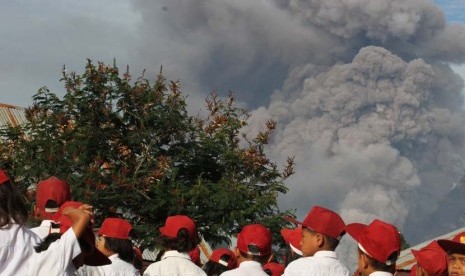 Sejumlah siswa SD Negeri 040482 mengikuti upacara bendera pada hari pertama masuk sekolah, ketika terjadi erupsi Gunung Sinabung, di Desa Gajah, Karo, Sumut, Senin (6/1).   (Antara/Irsan Mulyadi)