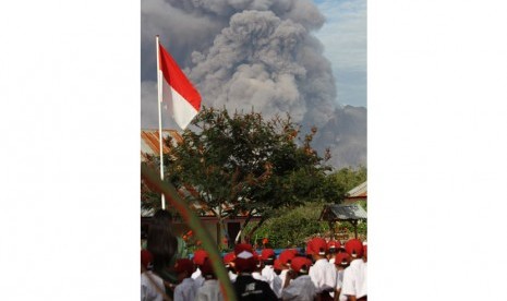 Sejumlah siswa SD Negeri 040482 mengikuti upacara bendera pada hari pertama masuk sekolah, ketika terjadi erupsi Gunung Sinabung, di Desa Gajah, Karo, Sumut, Senin (6/1).   (Antara/Irsan Mulyadi)