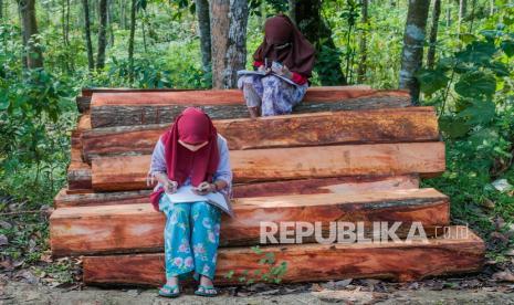 Sejumlah siswa SDN 1 Inten Jaya mengerjakan tugas melalui gawainya di Kampung Lebak Limus, Lebak, Banten, Senin (20/7/2020). Sejumlah siswa yang tinggal di daerah pelosok tersebut kesulitan dalam mengikuti kegiatan belajar mengajar (KBM) secara daring dan tepaksa menempuh perjalanan hingga satu kilometer dari kediamannya menuju ke dataran yang lebih tinggi agar mendapatkan jaringan internet guna mengerjakan tugas sekolah melalui gawai yang nantinya dikirim melalui aplikasi percakapan WhatssApp.