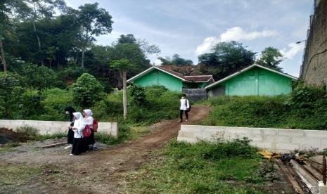 Sejumlah siswa SDN 2 Tugu Kota Tasikmalaya keluar melalui pintu belakang sekolah, Jumat (3/9). Mereka terpaksa harus melalui jalan belakang karena akses jalan depan ditutup tembok beton oleh pemilik lahan.