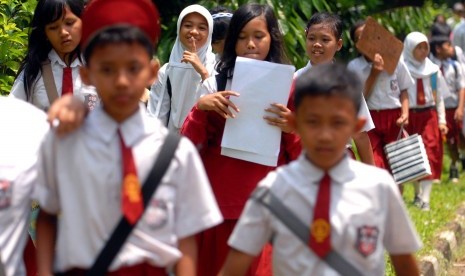 Sejumlah siswa Sekolah Dasar (SD) berjalan sambil membawa soal-soal setelah pelaksanaan uji coba ujian nasional. (ilustrasi) 