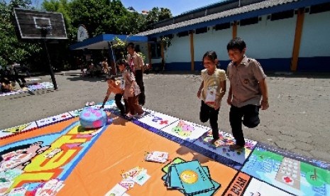 Sejumlah siswa Sekolah Dasar (SD) Budi Mulia Dua bermain permainan monopoli raksasa di SD Budi Mulia Dua, Seturan, Sleman, Yogyakarta, Jumat (13/4). Pembelajaran siswa didik melalui permainan luar ruang yang memerlukan banyak gerakan tersebut bertujuan unt