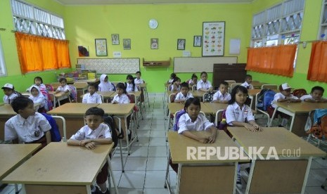 Sejumlah siswa-siswi murid baru kelas 1 memperhatikan gurunya saat memberi arahan pada hari pertama masuk sekolah di Sekolah Dasar Negeri (SDN) Pejaten Barat 10 Pagi, Jakarta Selatan, Senin (10/7).