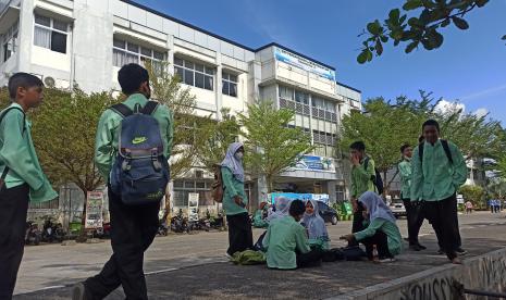 Sejumlah siswa SMP beraktivitas di luar gedung sekolah dan bersiap pulang akibat gempa di Padang, Sumatera Barat, Jumat (25/2/2022). Sejumlah sekolah di Padang memulangkan siswanya akibat gempa bumi bermagnitudo 6,2 SR yang mengguncang wilayah Sumatera Barat tepatnya 17 km timur laut Pasaman Barat pada Jumat pukul 08.39 WIB.