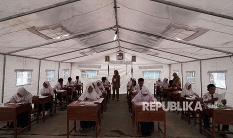 Sejumlah siswa SMP korban gempa bumi, mengikuti Ujian Nasional Kertas dan Pensil (UNKP) di tenda darurat milik Kemendikbud, di SMP N 2 Kalibening, Banjarnegara, Jawa Tengah, Senin (23/4).