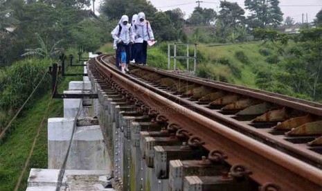 Sejumlah siswi melintas diatas rel kereta Cigombong, Kabupaten Bogor, Jawa Barat, Jumat, (14/3). (Republika/Agung Supriyanto)