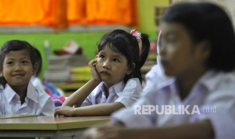 Sejumlah siswi murid baru kelas 1 memperhatikan gurunya saat memberi arahan pada hari pertama masuk sekolah di Sekolah Dasar Negeri (SDN) Pejaten Barat 10 Pagi, Jakarta Selatan, Senin (10/7).