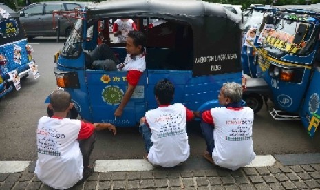 Sejumlah supir bajaj yang tergabung dalam Komunitas Bajaj DKI Jakarta menempelkan bajajnya dengan stiker bergambar Calon Presiden dan Calon Wakil Presiden Joko Widodo-Jusuf Kalla didepan Balai Kota, Jakarta, Selasa (24/6). 