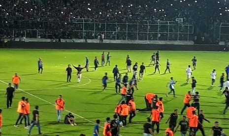 Sejumlah suporter Arema FC memasuki lapangan Stadion Kanjuruhan menjelang berakhirnya laga Arema FC vs Persib Bandung, Ahad (15/4). 