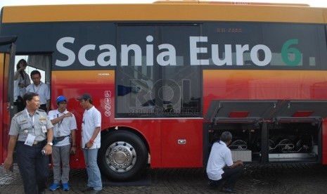   Sejumlah tamu undangan melihat bagian mesin Bus Scania Euro 6 saat melakukan uji coba melintas di Jalan Jendral Sudirman, Jakarta Pusat, Kamis (8/5). (Republika/Rakhmawaty La'lang)