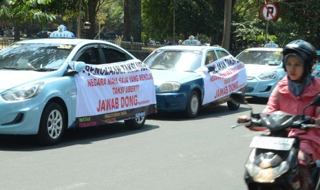 Sejumlah taxi memasang sepanduk menolak keberadaan Taksi Uber bertepatan dengan 'Seminar Fenomena Moda Transportasi Baru Kota Bandung di Era Digital' di Aula Barat, Kampus ITB, Kota Bandung, Senin (24/8)