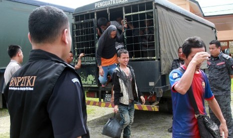  Sejumlah Tenaga Kerja Indonesia (TKI) turun dari truk tahanan imigrasi Malaysia saat tiba di perbatasan Entikong, Kabupaten Sanggau, Kalbar.