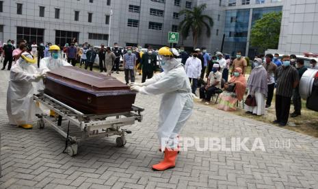 Sejumlah tenaga kesehatan mendorong peti mati berisi jenazah dokter Oki Alfin yang meninggal akibat COVID-19, di RSUD Arifin Achmad, Kota Pekanbaru, Riau, Sabtu (12/9/2020). Almarhum dokter Oki terpapar Virus Corona dari pasien yang dirawatnya di Puskesmas Gunung Sahilan 1 Kabupaten Kampar, dan kemudian turut menularkan virus ke isterinya. 