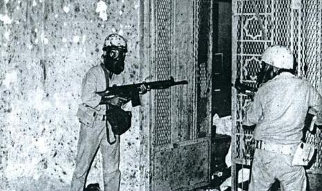 Sejumlah tentara Arab Saudi dengan memakai masker gas akan memasuki koridor bawah-tanah Masjidil Haram, Makkah. Pasukan ini akan meringkus teroris yang menyerang Masjid Suci pada 1979.