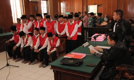  Sejumlah terdakwa kasus dugaan pembunuhan dan pengeroyokan aktivis lingkungan Salim Kancil mengikuti sidang di Pengadilan Negeri (PN) Surabaya, Jawa Timur, Kamis (10/3). 