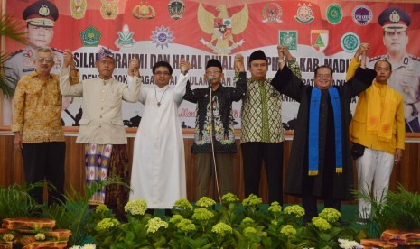 Sejumlah tokoh agama saling bergandengan tangan saat pembacaan pernyataan sikap terkait kasus Tolikara, Papua, seusai menghadiri halal bihalal di Mapolres Madiun, Jawa Timur, Jumat (24/7). 