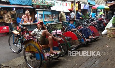 Sejumlah tukang becak yang tengah menunggu penumpang di daerah Pasar Bahari, Jakarta Utara, Kamis (18/1).