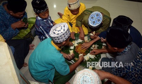 Sejumlah umat Islam berbuka puasa bersama dalam tradisi megibung di Masjid Al Muhajirin, Kepaon, Denpasar, Bali, Sabtu (26/5). 