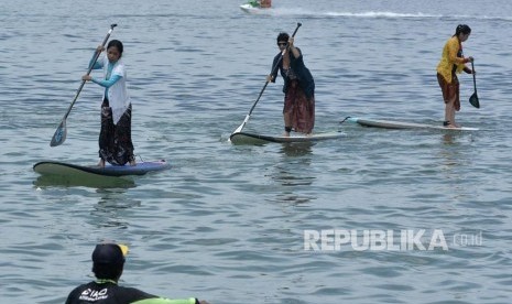 Sejumlah wanita dan wisatawan mancanegara mengenakan kebaya mendayung paddle board di kawasan Pantai Sanur, Bali (ilustrasi)