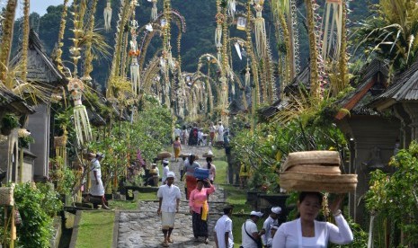 Sejumlah wanita menjunjung sesaji saat Hari Raya Galungan di Desa Adat Penglipuran, Bangli, Bali, Rabu (5/4).