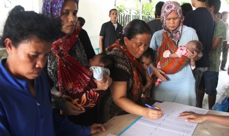 Sejumlah wanita pekerja migran ilegal menggendong anaknya yang masih balita saat mengisi formulir data di Pos Perlindungan Tenaga Kerja Indonesia di kota Dumai, Riau. ilustrasi