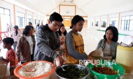 Sejumlah warga antre mengambil makanan di posko pengungsian Tongkonan Toraja, Kota Wamena, Kabupaten Jayawijaya, Papua, Sabtu (12/10/2019). 