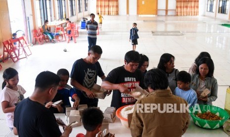 Sejumlah warga antre mengambil makanan di posko pengungsian Tongkonan Toraja, Kota Wamena, Kabupaten Jayawijaya, Papua, Sabtu (12/10/2019). 