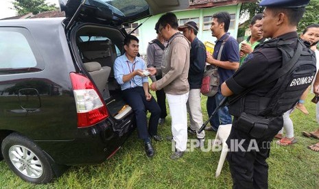 Sejumlah warga antre menukarkan uang pecahan dengan pengawalan anggota Kepolisian di halaman kantor kelurahan Manisrenggo, Kota Kediri, Jawa Timur, Senin (29/5). Bank Indonesia sebagai salah satu unsur dari Tim Pengendali Inflasi Daerah (TPID) membuka layanan penukaran uang lebih awal di 46 kantor kelurahan se-Kota Kediri guna meminimalisir mayarakat menggunakan jasa penukaran uang ilegal di pinggir-pinggir jalan.