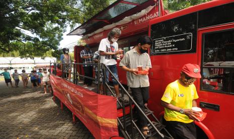 Sejumlah warga antre saat pembagian makanan gratis di Klaten, Jawa Tengah, Kamis (30/12/2021). Warung makan gratis dengan konsep menggunakan bus itu didirikan oleh komunitas Sedekah Menebar Manfaat yang diharapkan dapat membantu warga yang kurang mampu.