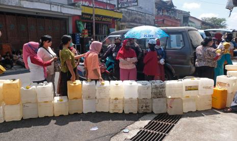 Sejumlah warga antre untuk membeli minyak goreng curah di sebuah toko sembako di kompleks pasar KlliwonTemanggung, Jawa Tengah, Senin (4/4/2022). Menurut pedagang mahalnya harga minyak goreng kemasan membuat warga memilih membeli minyak goreng curah seharga Rp15.500 per liter meski harus antre lama dan harus menunjukan fotokopi KTP.