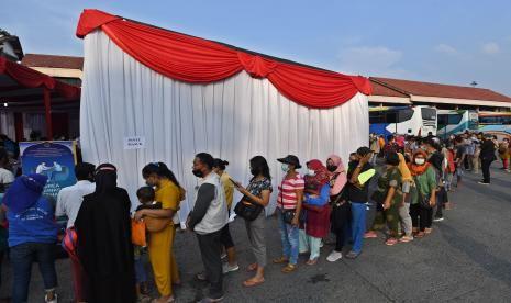 Sejumlah warga antre untuk vaksinasi COVID-19 dosis ketiga (booster) di posko vaksinasi Terminal Bus Kampung Rambutan, Jakarta, Ahad (17/4/2022). Posko tersebut bertujuan untuk memfasilitasi masyarakat yang belum melaksanakan vaksinasi booster sebagai syarat perjalanan mudik Lebaran 2022 mendatang sekaligus sebagai upaya antisipasi penularan COVID-19.