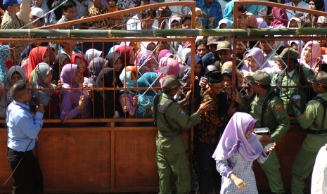 Sejumlah warga berdesakan masuk ke dalam Tempat Pemungutan Suara (TPS) saat Pemilihan Kepala Desa (Pilkades) serentak 2018 di Desa Danawarih, Kabupaten Tegal, Jawa Tengah, Senin (17/12/2018).