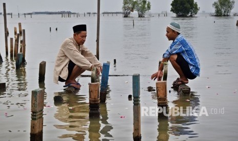 Sejumlah warga berdoa saat berziarah di makam kerabatnya di tempat pemakaman umum (TPU) yang terdampak abrasi di Tambaklorok, Semarang, Jawa Tengah. 