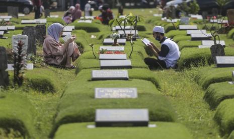 Sejumlah warga berdoa saat ziarah kubur di Pemakaman Covid-19, Srengseng Sawah, Jakarta, Senin (2/5/2022). 