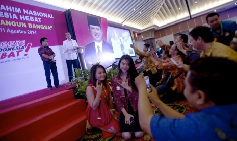 Sejumlah warga berfoto di sela-sela Presiden terpilih periode 2014-2019 Joko Widodo memberi sambutan dalam Musyawarah dan Silaturahmi Nasional Rumah Koalisi Indonesia Hebat di Jakarta, Senin (11/8) malam.