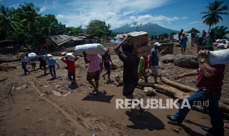 Sejumlah warga bergotong royong memindahkan bantuan logistik dari sejumlah lembaga dan pemerintah untuk korban banjir bandang di Adonara Timur, Kabupaten Flores Timur, Nusa Tenggara Timur (NTT), Rabu (7/4/2021). Bencana alam yang melanda pada Minggu (4/4) tersebut mengakibatkan puluhan orang meninggal dunia dan ratusan warga mengungsi.