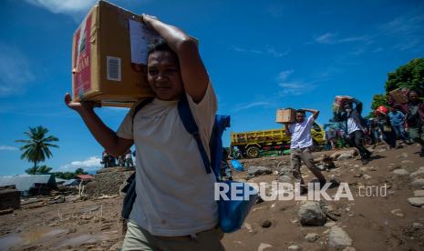 Sejumlah warga bergotong royong memindahkan bantuan logistik dari sejumlah lembaga dan pemerintah untuk korban banjir bandang di Adonara Timur, Kabupaten Flores Timur, Nusa Tenggara Timur (NTT), Rabu (7/4/2021). Bencana alam yang melanda pada Minggu (4/4) tersebut mengakibatkan puluhan orang meninggal dunia dan ratusan warga mengungsi. 