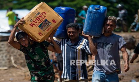 Sejumlah warga bergotong royong memindahkan bantuan logistik dari sejumlah lembaga dan pemerintah untuk korban banjir bandang di Adonara Timur, Kabupaten Flores Timur, Nusa Tenggara Timur (NTT), Rabu (7/4/2021). Bencana alam yang melanda pada Minggu (4/4) tersebut mengakibatkan puluhan orang meninggal dunia dan ratusan warga mengungsi. 