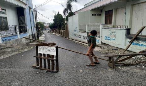 Sejumlah warga berjaga di akses masuk ke Kampung Sambongpari Kulon dan Sambongpari Kidul, Kelurahan Sambongpari, Kecamatan Mangkubumi, Kota Tasikmalaya, Senin (21/6). Askes masuk ke kampung itu dibatasi lantaran adanya belasan warga yang terkonfirmasi positif Covid-19.