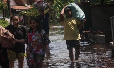 Sejumlah warga berjalan melewati jalan di sekitar rumahnya yang tergenang banjir rob di Pekalongan, Jawa Tengah (ilustrasi)