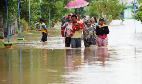 Sejumlah warga berjalan menerobos banjir untuk mengungsi di Desa Garon, Kecamatan Balerejo, Kabupaten Madiun, Jawa Timur, Kamis (7/3/2019). 