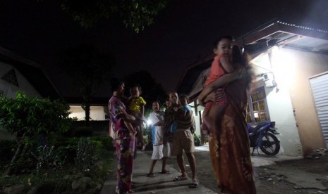 Sejumlah warga berkumpul di luar rumah ketika terjadi gempa di Medan, Sumatra Utara, Senin (16/1) malam.