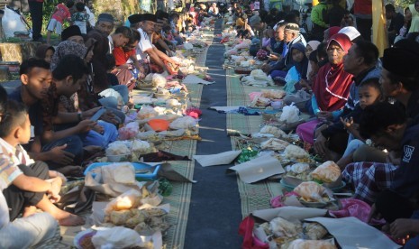 Sejumlah warga berkumpul saat mengikuti Tradisi Kenduri Ketupat Syawalan di lereng Gunung Merapi, Mlambong, Sruni, Musuk, Boyolali, Jawa Tengah, Rabu (12/6/2019). 